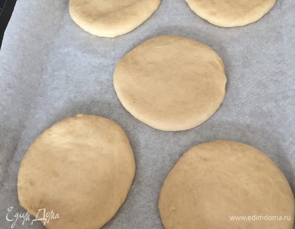 Теперь каждый шарик раскатаем в лепешку толщиной 1 см. Заготовки размешаем на противне, застеленном бумагой. Оставляем на расстойку на полчаса
