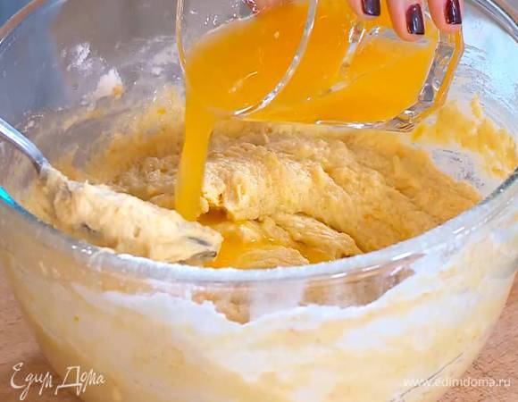 В несколько приемов всыпать большую часть муки, все вымешать, затем влить апельсиновый сок и перемешать.