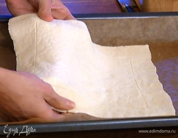 Отступая на 2 см от края, прочертить ножом квадрат, не прорезая тесто до конца, чтобы получились бортики. Противень выстелить бумагой для выпечки и выложить пласт теста.