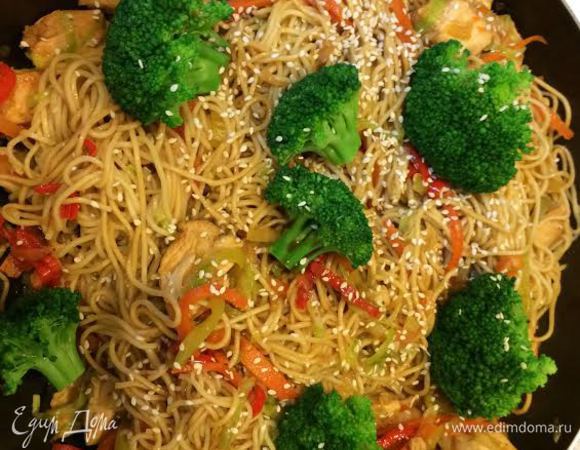 Добавить лапшу, перемешать. Затем брокколи, кунжут и остатки соевого соуса.