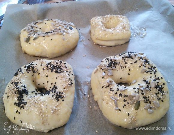 Выкладываем бублики на расстоянии ~3 см друг от друга на противень, смазываем желтком и посыпаем смесью семечек подсолнуха, льна, кунжута, мака или др. 