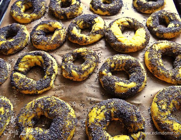 На противень стелим пергамент, посыпаем манкой и раскладываем бублики. На стандартный противень влезли все!