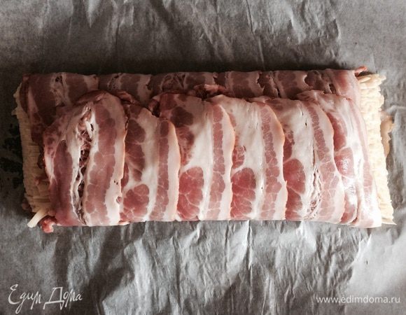 Заворачиваем одну сторону к себе, помогая бумагой. Затем аналогично другую — от себя, накрывая ей первую.