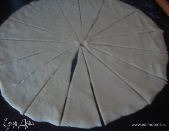 Стол на котором мы будем работать припыляем мукой. Берем одну часть теста раскатываем в круг диаметром 35 сантиметров разрезать получившийся круг из теста на 16 секторов.