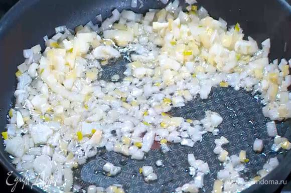 Разогреть в сковороде со съемной ручкой оливковое масло и обжарить лук и чеснок до прозрачности.
