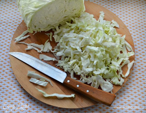 Подготовьте капусту. Очистите ее от внешних листьев и нарежьте тонкой соломкой.