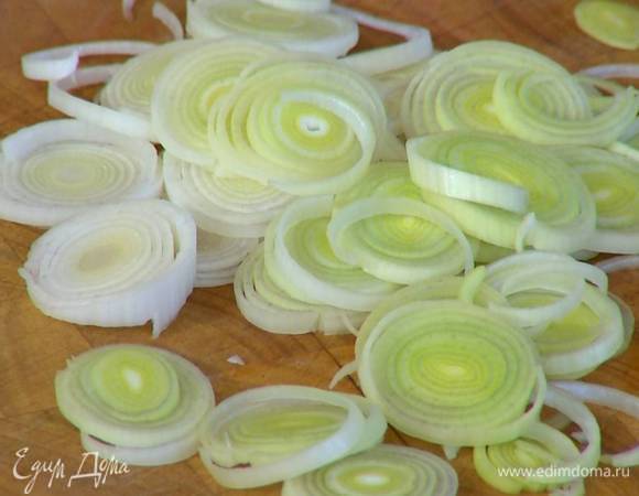 Светлую часть лука-порея нарезать тонкими кольцами.