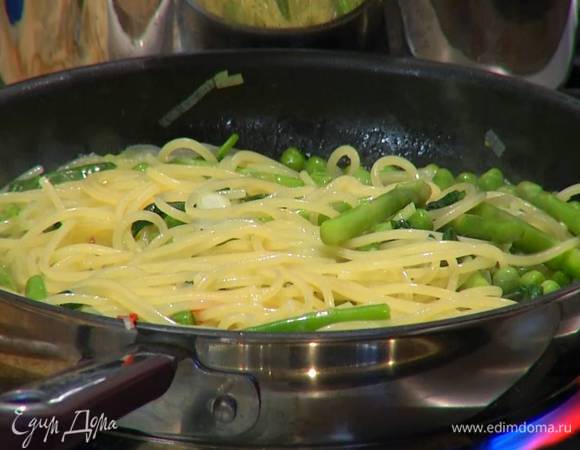 Выложить в сковороду с овощами готовые спагетти, влить немного воды, в которой они варились, затем добавить шпинат, перемешать и дать ему поплыть.