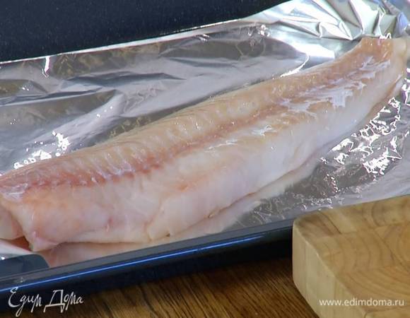 Противень выстелить в несколько слоев пищевой фольгой, так чтобы получился карман, внутрь кармана вложить треску.