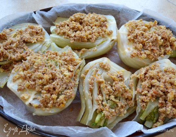 Застелить бумагой для выпечки дно жаропрочной формы, уложить в нее подготовленный фенхель начиненной стороной вверх и сбрызнуть все растительным маслом. Влить 4 ст. л. горячей воды и запекать на среднем уровне разогретой духовки до темно-золотистого цвета.