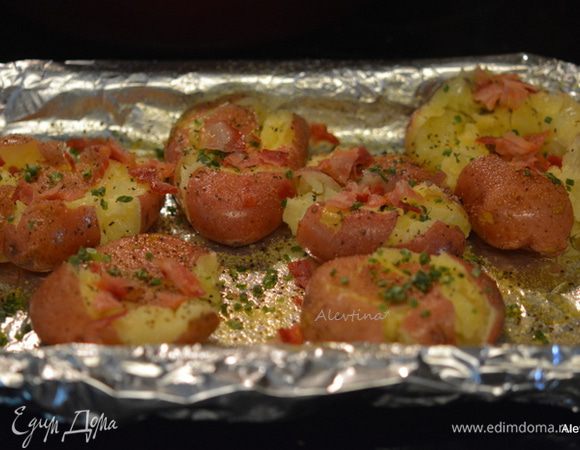 Картофель сбрызнуть оливковым маслом. Посыпать сверху чесночным порошком, солью и черным перцем по вкусу, беконом и шнит-луком колечками.
Поставить в духовку на 20-25 мин.
Или в гриль с крышкой. 
