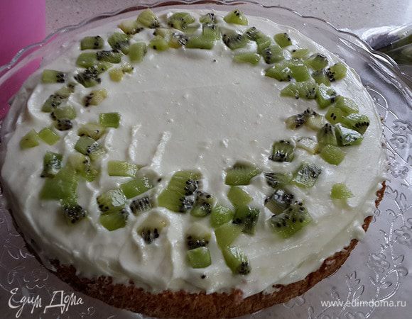 Смазываем нижний бисквит и посыпаем нарезанным киви.