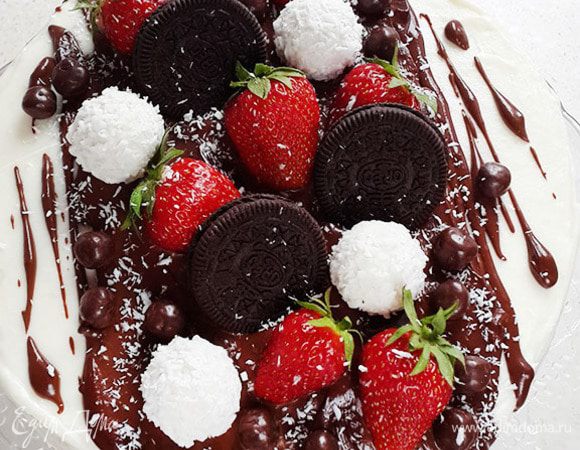 Поливаем торт горячей глазурью. Украшаем клубникой, печеньем и конфетами. Посыпаем стружкой. Убираем в холод минимум на 30 минут.