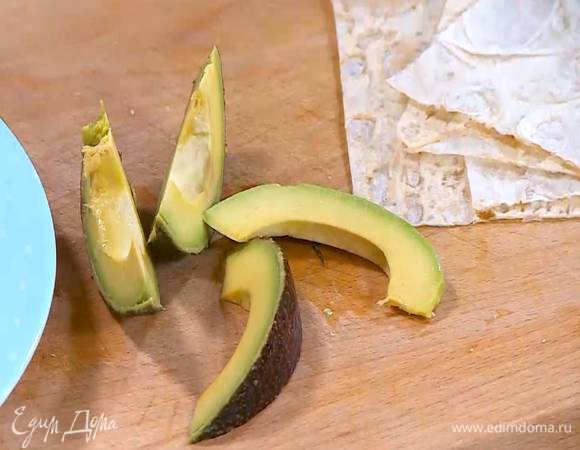 Авокадо почистить, нарезать длинными полосками и сбрызнуть лимонным соком.