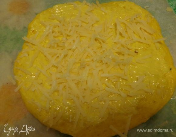 Каждую часть тонко раскатывать и промазывать масляной смесью соответствующего цвета. Каждую лепешечку посыпать тертым сыром и чесноком. 