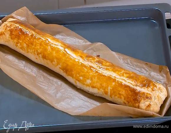 Поместить штрудель вместе с бумагой на противень и выпекать в разогретой духовке 25‒30 минут.