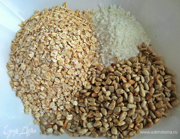 Смешать хлопья, кокос и семечки.
