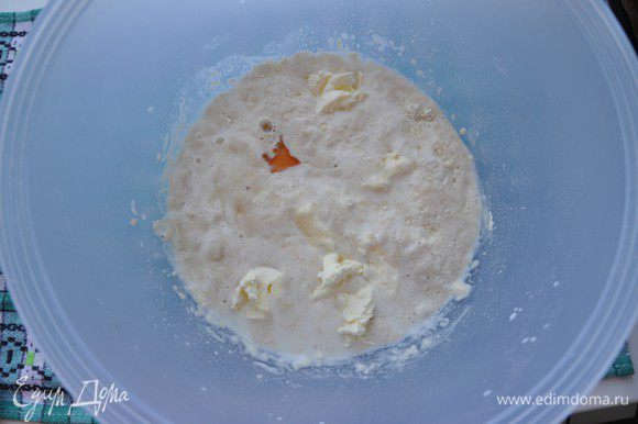 В ожившие дрожжи добавить воду, яйцо, оставшийся сахар, мягкое сливочное масло кусочками. Хорошо перемешать.