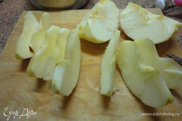 Включить духовку для разогрева до 180°С. Яблоки очистить от кожицы и сердцевины и нарезать тонкими дольками.