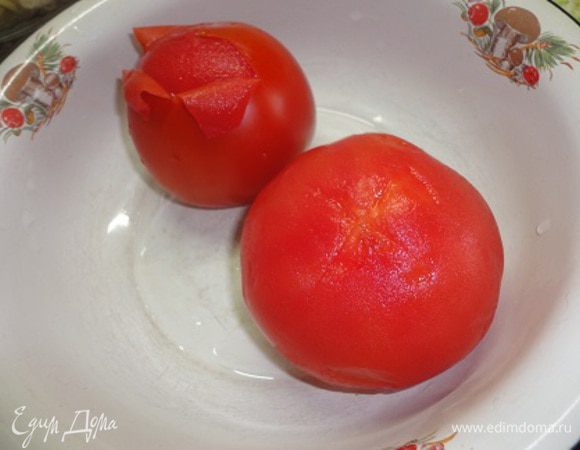 Помидоры залить кипятком. Оставить на пару минут, а затем поместить в холодную воду. Это поможет легко их очистить от кожицы. Помидоры нарезать средними кубиками.