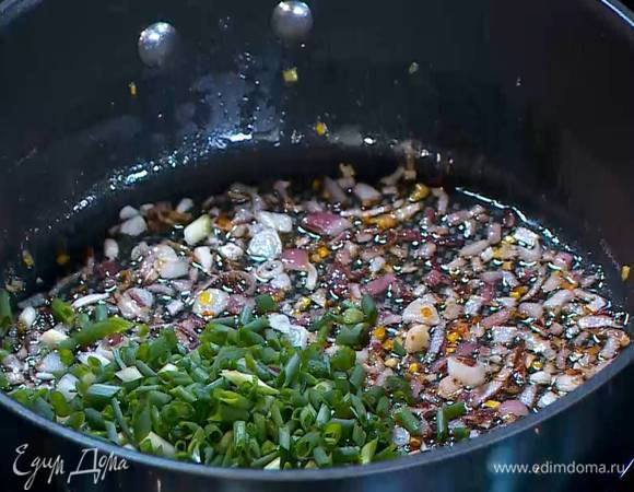 Зеленый лук мелко порезать, добавить в сковороду и обжаривать все еще пару минут.