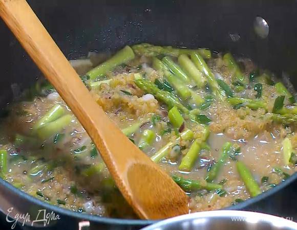 Стебли спаржи, удалив грубые черенки, разрезать на три части, выложить к булгуру, все посолить, поперчить, перемешать, затем влить еще немного бульона.