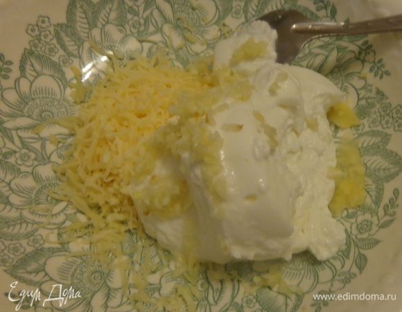 Тем временем сделать начинку: натереть сыр и чеснок, добавить творог и все хорошо размешать.