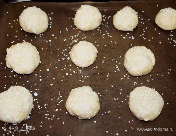 Готовое тесто делим на одинаковые кусочки и скатываем круглые булочки, которые выкладываем на противень, застеленный бумагой для выпечки.