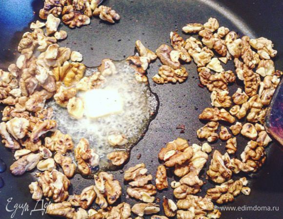 Обжарить на сковороде без масла грецкие орехи в течение 8-10 минут. Снять с огня и добавить к орехам щепотку соли и 1 столовую ложку сливочного масла. Перемешать, вы увидите, как орехи покроются тоненькой пленкой, будто закарамелизируются. Отложить орехи в сторону и дать им остыть.