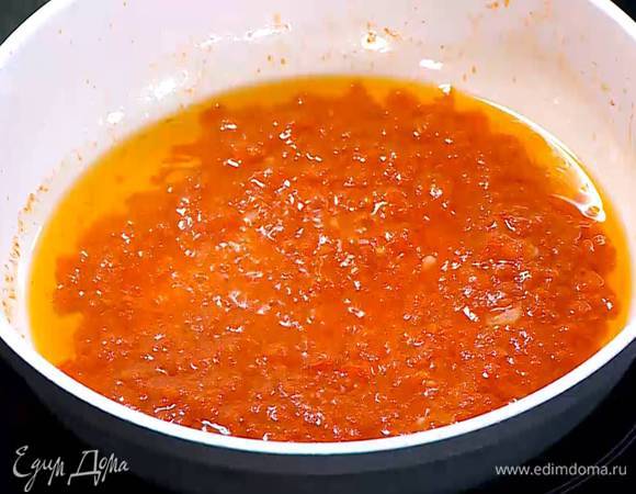 Перец чили мелко порезать, добавить в сковороду с чесноком и слегка обжарить, затем добавить помидоры и на среднем огне уварить соус.