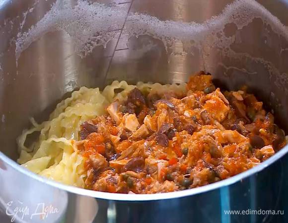 Слить воду из макарон, затем вернуть их обратно в кастрюлю, добавить соус, влить оставшееся оливковое масло и все перемешать.