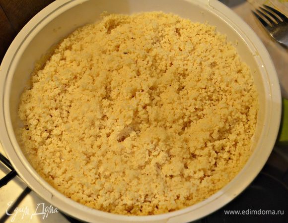 Кускус засыпать в емкость, залить 350 мл кипятка, накрыть крышкой и дать постоять около 15 минут. Затем размять вилкой и перемешать.