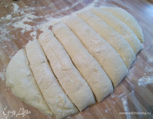 Тесто выложить на посыпанную мукой поверхность и разделить на 8 частей, накрыть пленкой и оставить на отдых на 10 минут. 