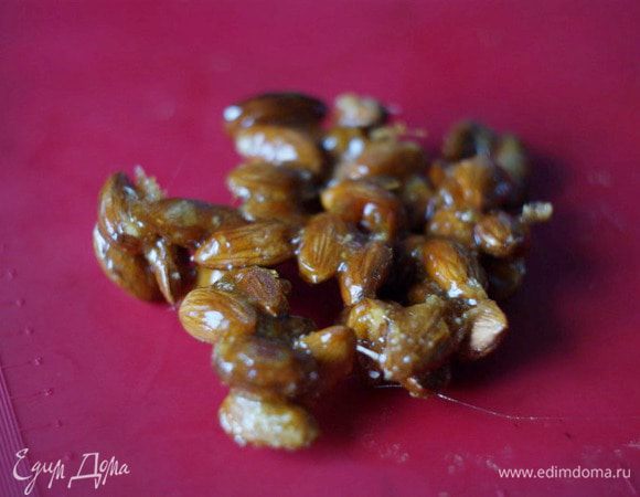 Сначала сделаем пралине. Его получается много и оно потом останется для другой выпечки.
Для пралине на сковороде расплавим сахар и кинем к нему миндаль (его можно предварительно прожарить-просушить в духовке). Карамелизируем орехи, помешивая и давая карамели их полностью покрыть.
Выкладываем на силиконовый коврик и даем остыть.
Перемалываем комбайном или блендером в крошку.