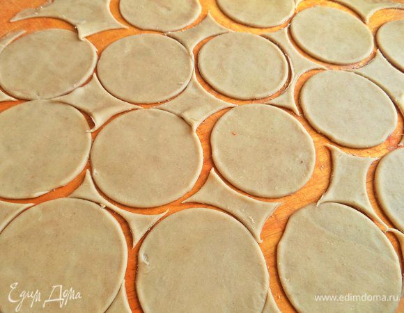 Подошедшее тесто вынуть на доску с мукой, раскатать тонко. Вырезать стаканом кружочки.