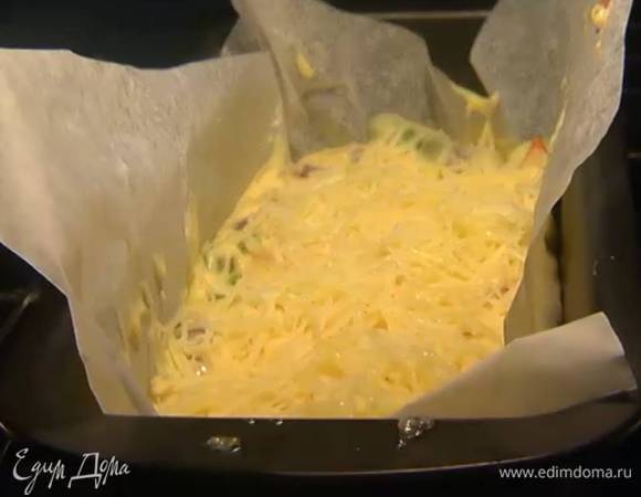 Продолговатую форму выстелить бумагой для выпечки, влить тесто, равномерно распределить и посыпать оставшимся сыром.