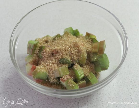 Ревень помойте, почистите и нарежьте кусочками, смешайте с коричневым сахаром.