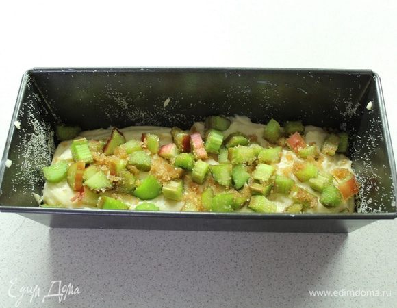 В форму для кексов выложите половину теста, выложите ревень с сахаром.