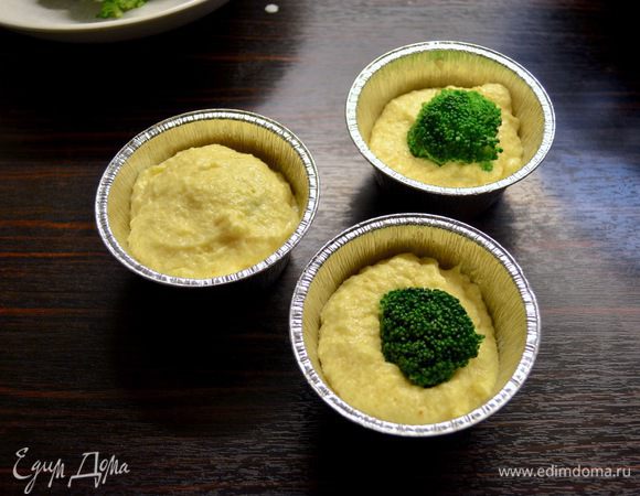 Подготовить формочки для кексов. Смазать их слегка маслом и присыпать манкой. Заполнить каждую формочку наполовину тестом, в центр вставить соцветие брокколи. Добавить сверху еще по ложке теста, чтобы закрыть (спрятать) капусту в тесте.