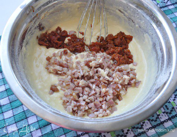 Вяленое томаты мелко порезать. Добавить в тесто поджаренный бекон и томаты и хорошо перемешать. 