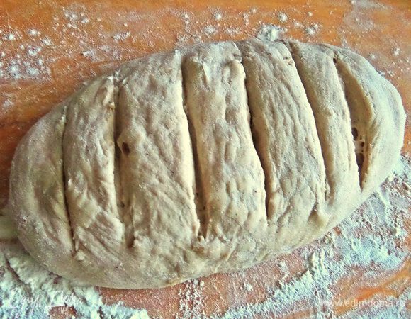 Переносим на доску с мукой, формируем батон, делаем надрезы.