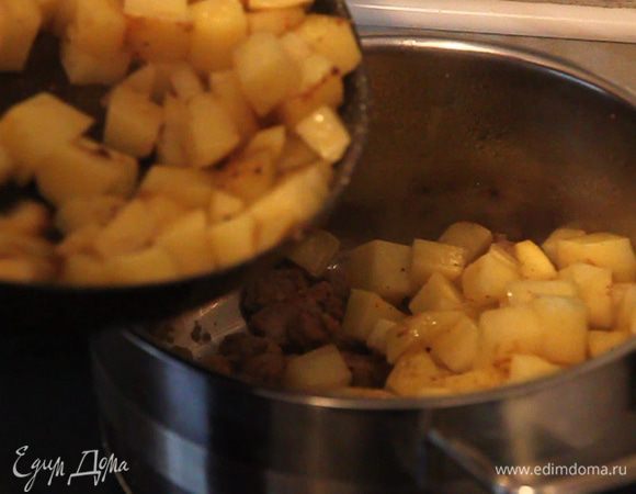 Поджаренный картофель выкладываем в кастрюлю к мясу.
