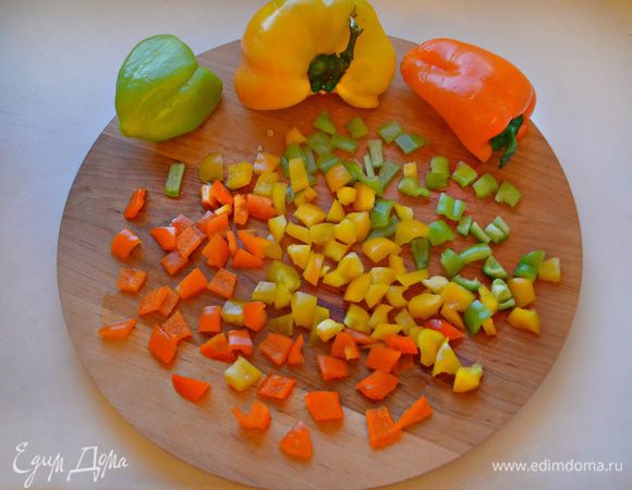 Половинки разноцветного болгарского перца помыть, освободить от семян и перегородок, нарезать небольшими кубиками. Разогреть в сковороде растительное масло, слегка обжарить чеснок и затем вынуть. В полученном чесночном масле обжарить перец в течение 3-5 минут.