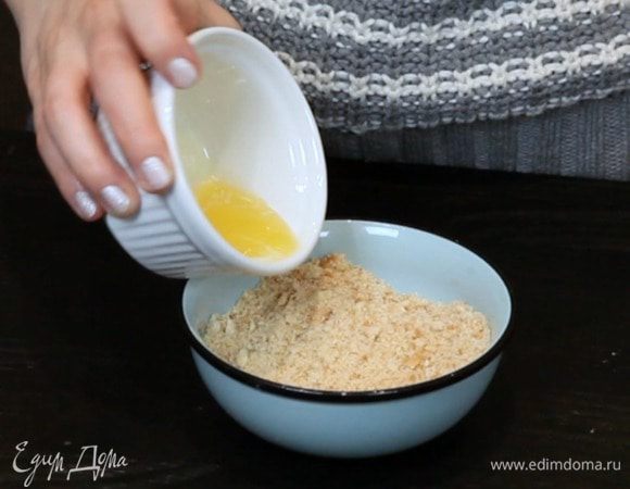 Смолоть печенье в крошку и перемешать с растопленным сливочным маслом.