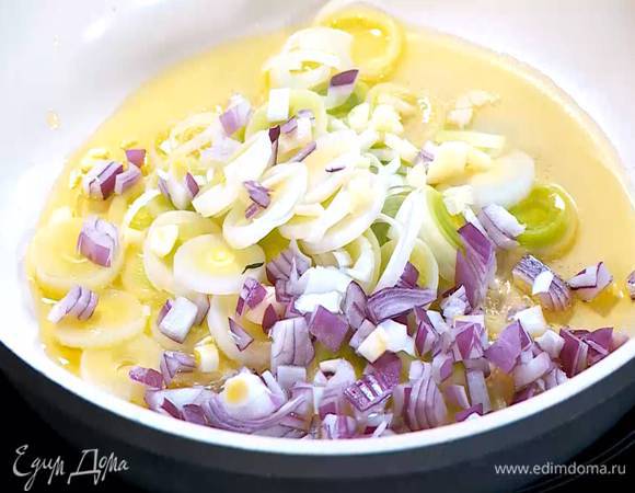 Разогреть в сковороде 1 ст. ложку оливкового масла и обжарить порей, красный лук и чеснок.