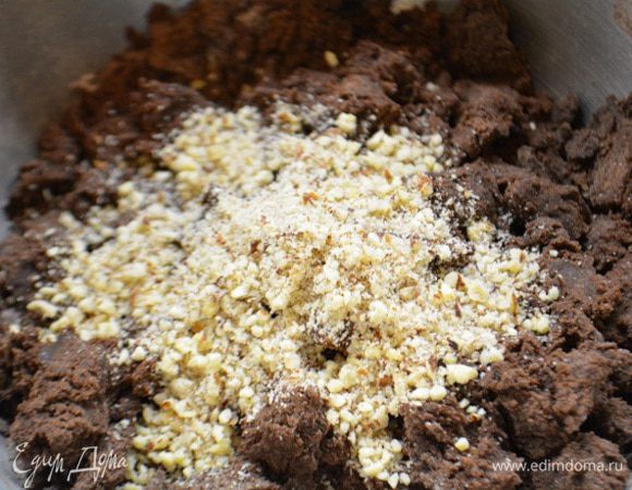 Разбить большое яйцо и снова взбить. К масляно-яичной смеси добавить измельченные орехи, перемешать. В эту смесь постепенно добавить мучную смесь и замесить мягкое тесто.