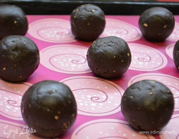 Из этого теста скатать небольшие шарики. Каждый шарик приплюснуть, на него положить кусочек шоколадки и завернуть края, формируя шарик.