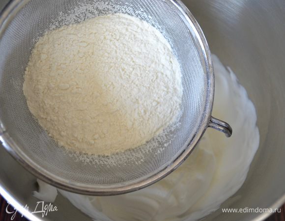 Добавить просеянную муку и осторожно перемешать лопаткой плавными заворачивающими движениями, чтобы не было комочков. Тесто получается очень нежной и гладкой консистенции.