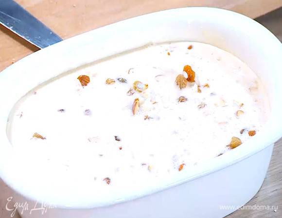 Керамическую жаропрочную форму для выпечки смазать сливочным маслом, выложить рис с миндалем и изюмом и залить яично-молочной массой.