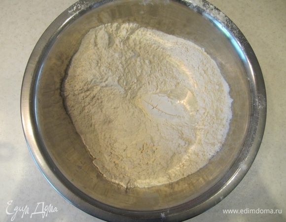 3/4 всей просеянной муки смешать с солью и сухими дрожжами.